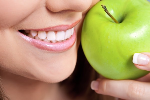 healthy teeth and green apple, close up